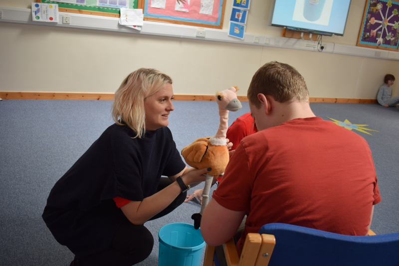 Ostrich toy and a person smiling 