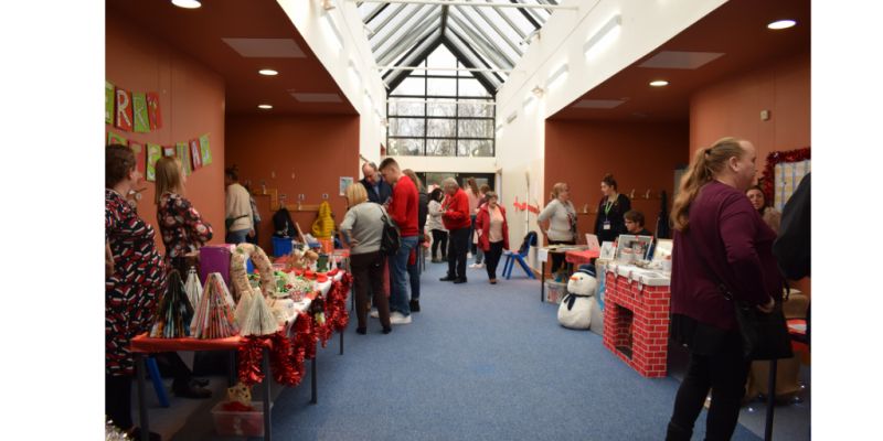 Image of the corridor where the stalls where lined, with people conversing. 