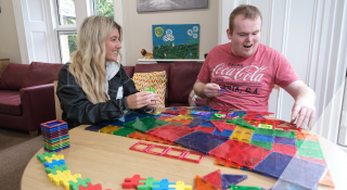 Two people playing with coloured shapes